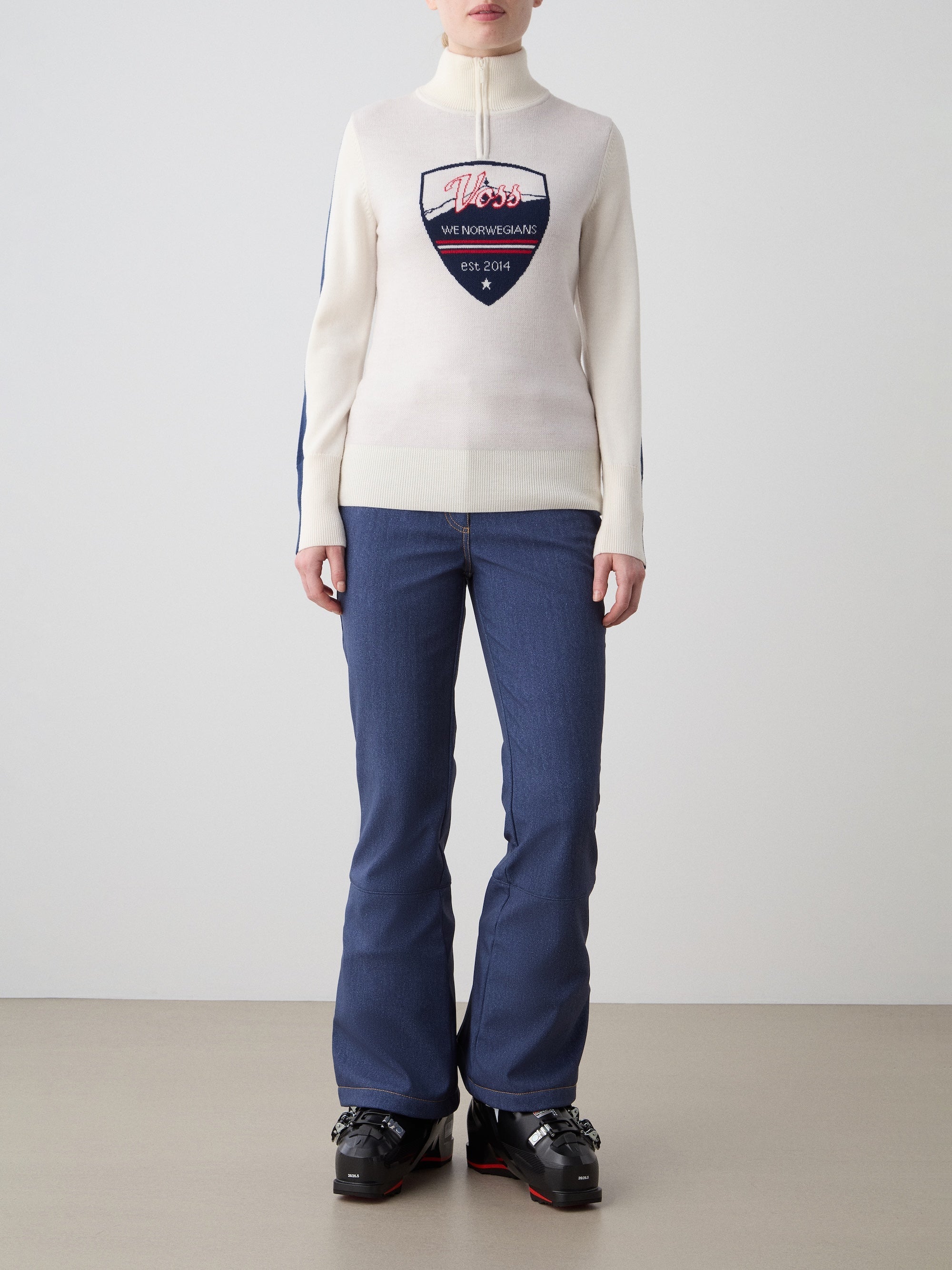 We Norwegians | FW25 | The model is wearing womens Afterski zip-up in cream which has the logo and 1/4th zipper in the front, against an off white background | Front view