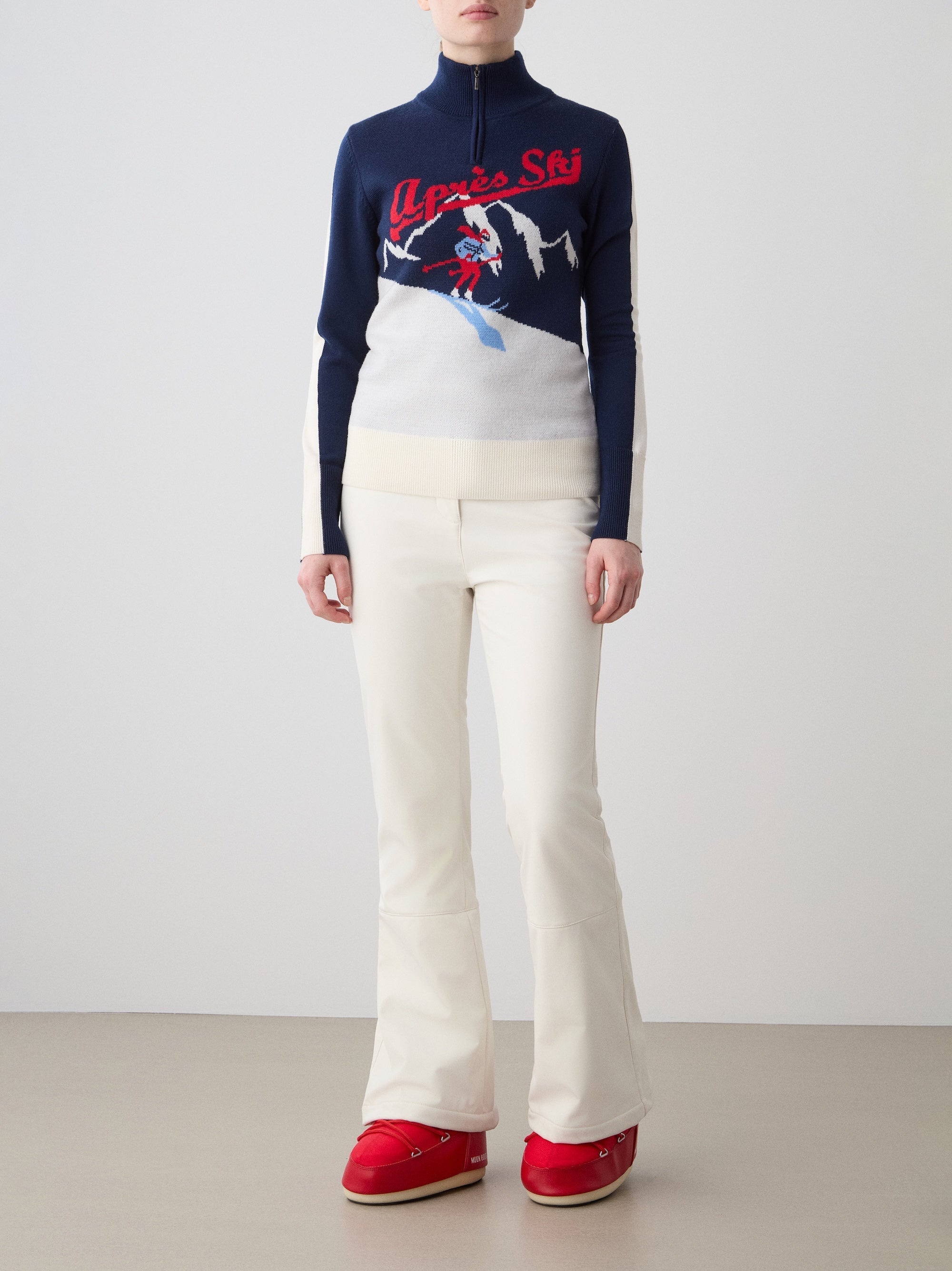 We Norwegians | FW25 | The model is wearing womens Afterski zip-up in navy blue which has the logo and 1/4th zipper in the front, against an off white background | Front view